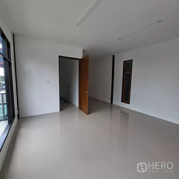 Warehouse for rent in Lam Luk Ka, Pathum Thani - Second-floor office room with large windows and balcony access, suitable for management workspace.