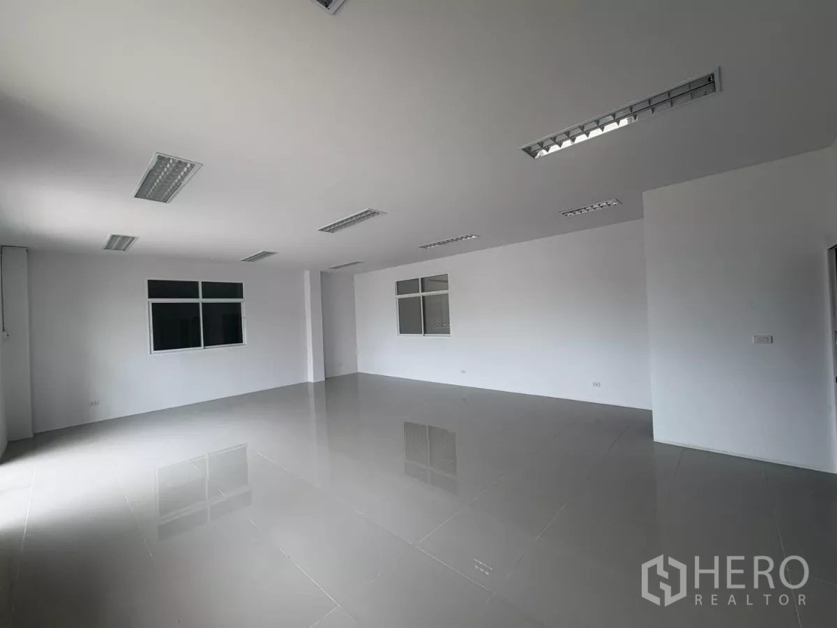 Factory for rent in Phra Samut Chedi, Samut Prakan - Large open-plan office space with multiple windows and glossy tile floor.