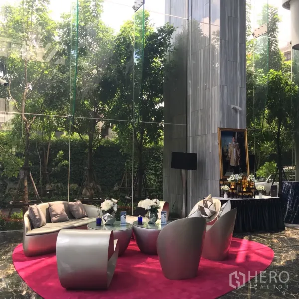 Condominium for rent or sale in Watthana, Bangkok - Elegant condo lobby lounge with modern furniture and double-height glass walls facing greenery.