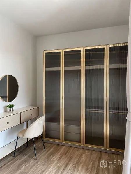 Detached House for rent in Bang Kapi, Bangkok - Dressing room with gold-framed glass wardrobes and vanity table.