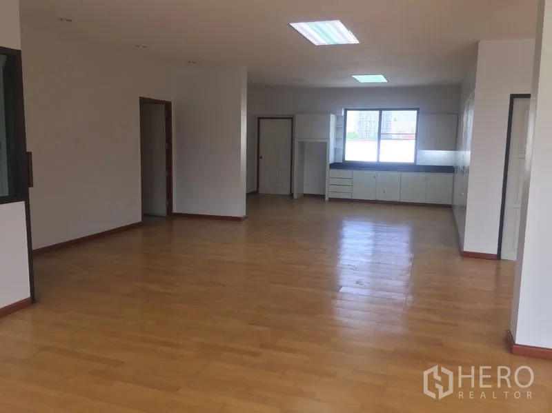 Home Office for rent in Watthana, Bangkok - Open workspace with wood floors leading to a pantry and side rooms.