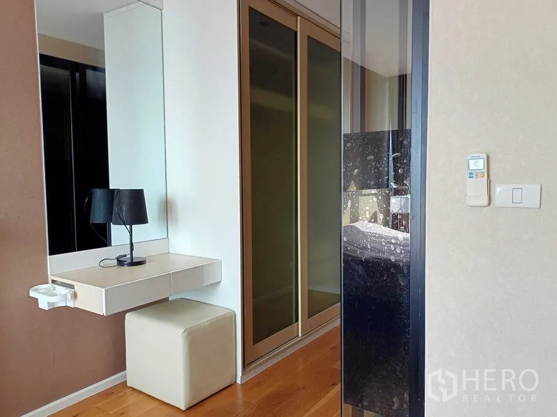 คอนโด ให้เช่าในWatthana, Bangkok - มุมห้องนอนพร้อมโต๊ะเครื่องแป้ง กระจกส่องเต็มตัว ที่นั่งออตโตมัน และตู้เสื้อผ้าบานเลื่อน.