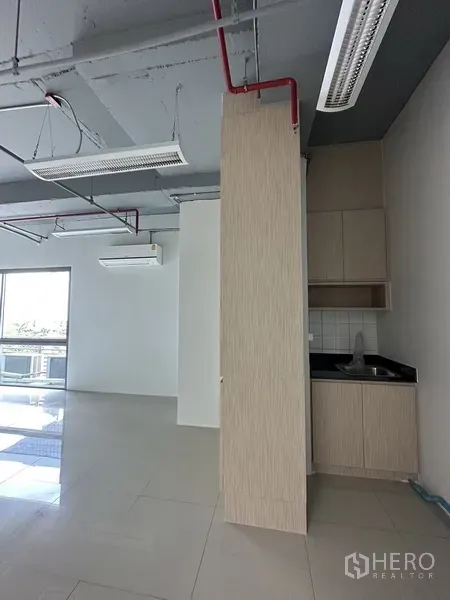 办公空间 出租在Khlong Toei, Bangkok - 办公室内的茶水间，带水槽与浅木色橱柜，旁有玻璃滑门采光。