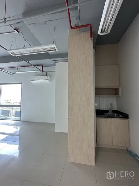 办公空间 出租在Khlong Toei, Bangkok - 办公室内的茶水间，带水槽与浅木色橱柜，旁有玻璃滑门采光。