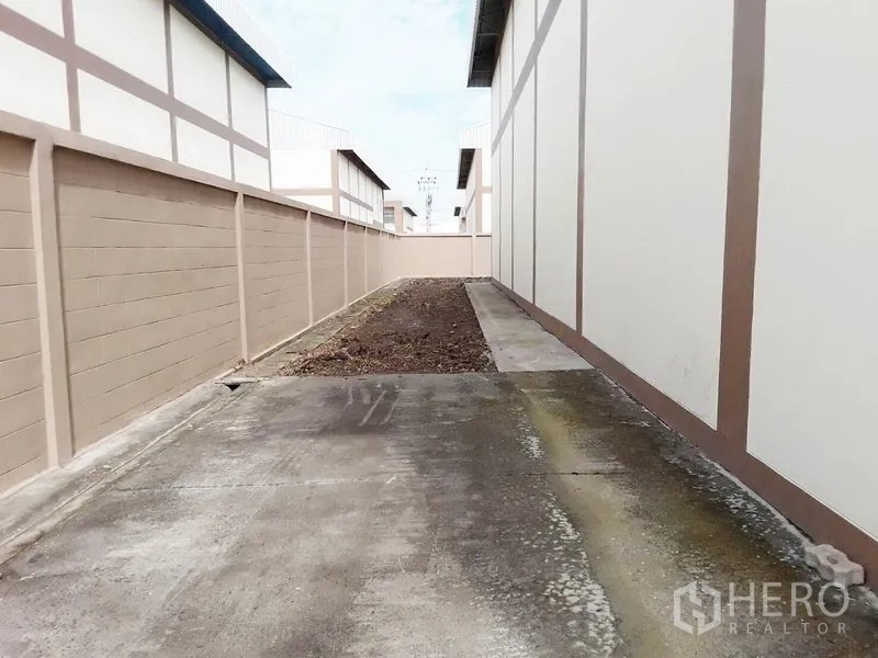 工厂 出租或出售在Pathum Thani - 仓库后方服务通道，设排水与混凝土路面。