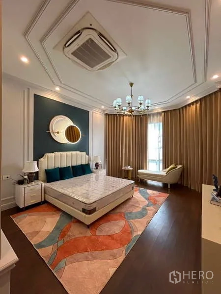 Detached House for sale in Bang Kapi, Bangkok - Spacious master bedroom with chandelier, accent wall and chaise by tall window.