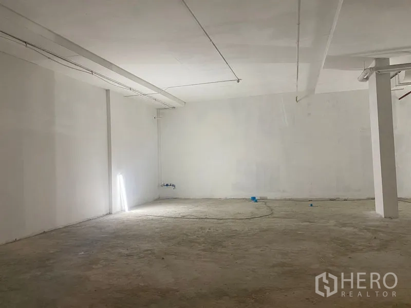 พื้นที่ขายปลีก ให้เช่า - ห้องเปล่าขนาดใหญ่ พื้นคอนกรีต ผนังสีขาว มีจุดสาธารณูปโภคพร้อมตกแต่ง