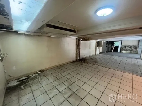 零售空间 出租在Watthana, Bangkok - 低天花的瓷砖房间，带天窗，适合做仓储或员工区。