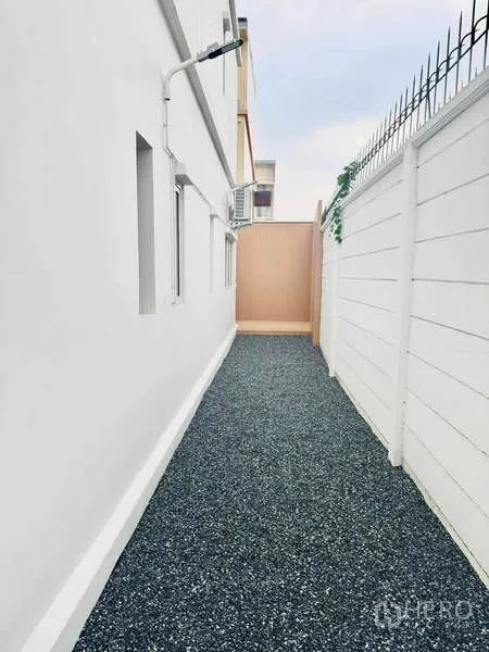 ทาวน์เฮาส์ ให้เช่าในSuan Luang, Bangkok - ทางเดินข้างบ้านโรยหินเกล็ด กำแพงสีขาวสูง พร้อมคอมเพรสเซอร์แอร์ภายนอก