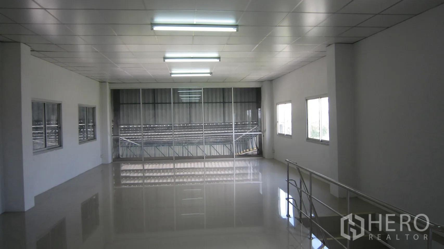 Warehouse for rent in Bang Sao Thong, Samut Prakan - Bright mezzanine office with windows, glass partition and polished floor overlooking the warehouse.
