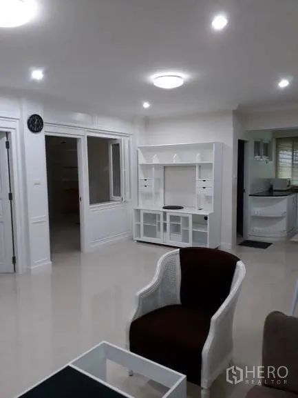 Condominium for rent in Pathum Wan, Bangkok - Bright open-plan living room with white built-in TV unit and recessed lighting in a Pathum Wan condo.