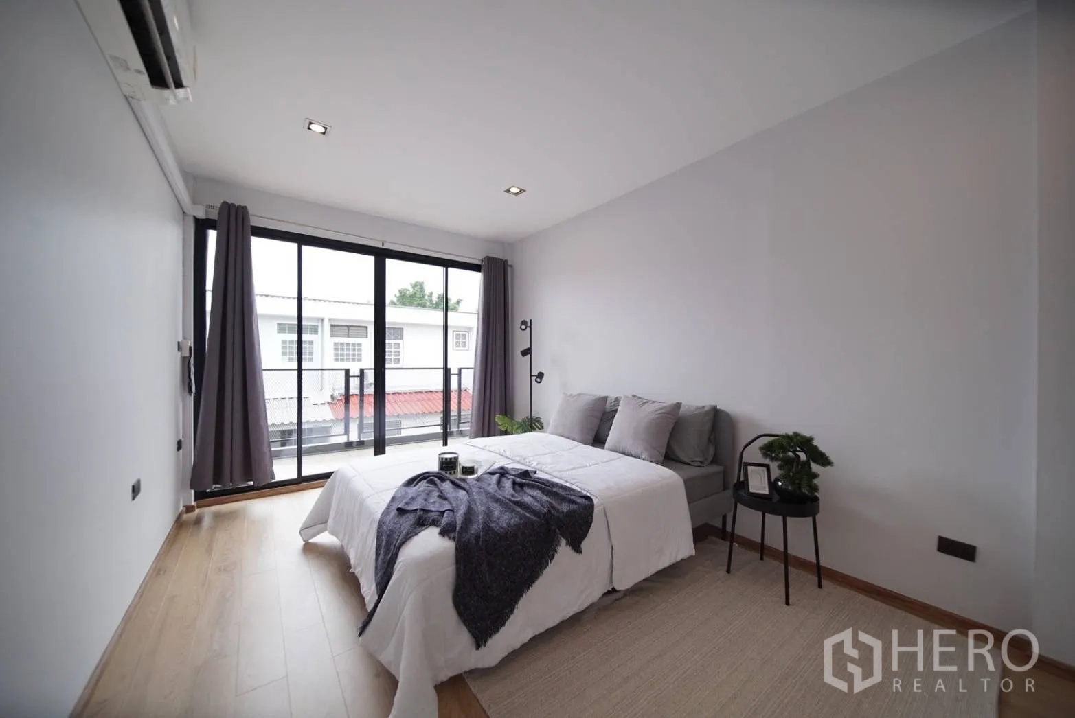 ทาวน์เฮาส์ ให้เช่าในWatthana, Bangkok - ห้องนอนสว่างพร้อมประตูกระจกลื่นออกสู่ระเบียง พื้นไม้