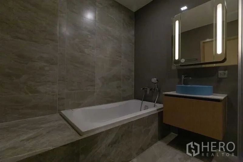 คอนโด ให้เช่าในWatthana, Bangkok - ห้องน้ำสไตล์โมเดิร์นพร้อมอ่างอาบน้ำ ผนังลายหิน กระจกมีไฟ และเคาน์เตอร์ลอย