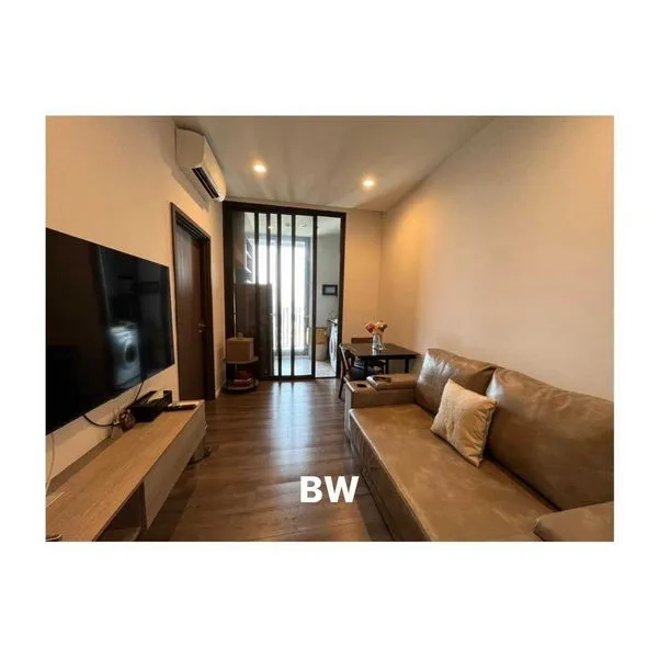Condominium for rent in Phra Khanong, Bangkok - Compact living room with leather sofa, wall-mounted TV and sliding glass door