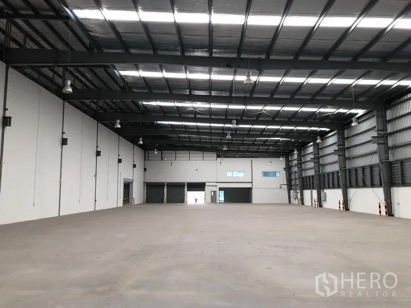 工厂 出租在Bang Sao Thong, Samut Prakan - 大型厂房大厅，多个卷帘门与夹层办公室窗户
