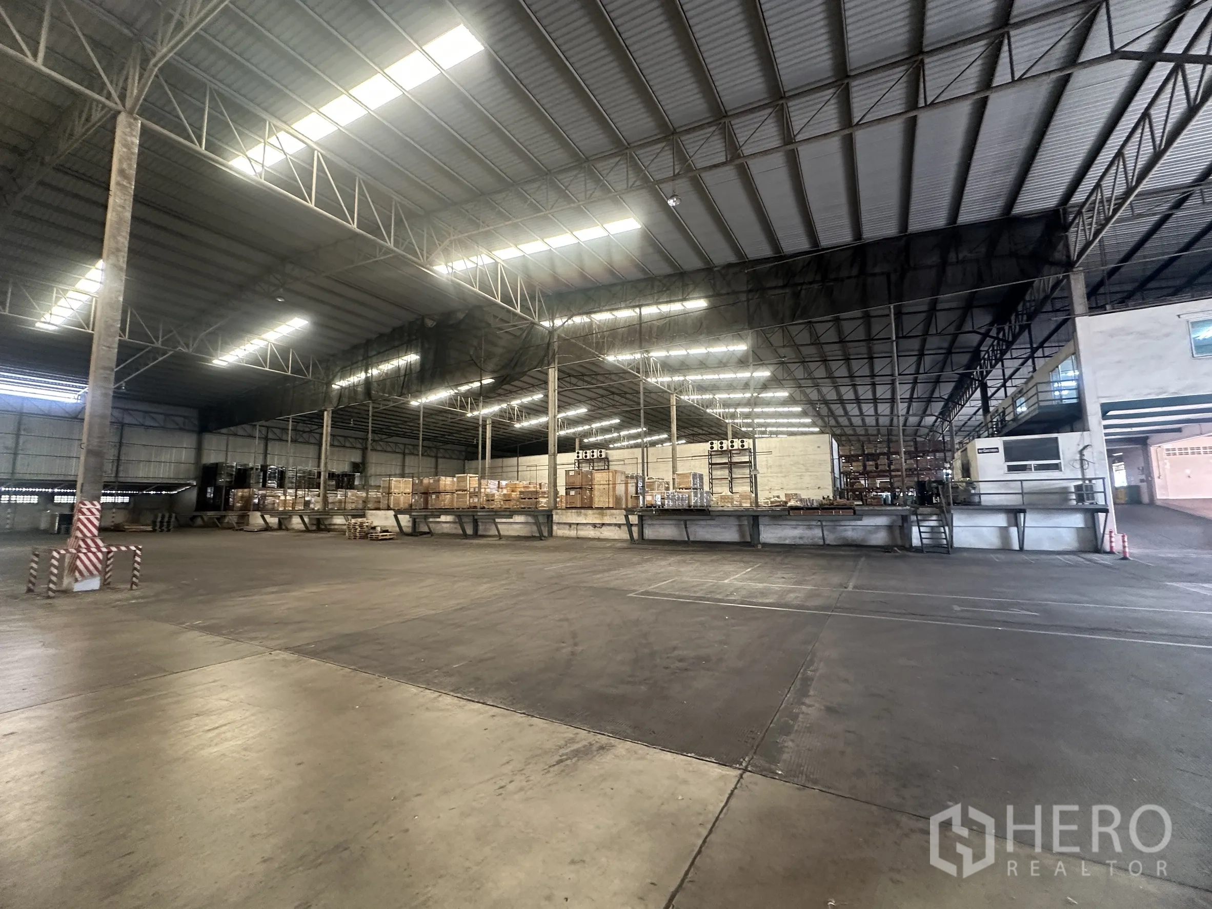 仓库 for rent in Bang Pa-in, Phra Nakhon Si Ayutthaya - 仓库内部钢结构大开间，设升高式装卸平台与托盘货物。