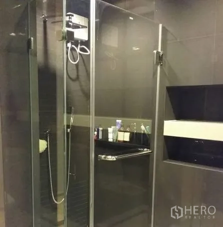 Condominium for rent in Sathon, Bangkok - Modern bathroom with frameless glass shower enclosure and handheld shower.