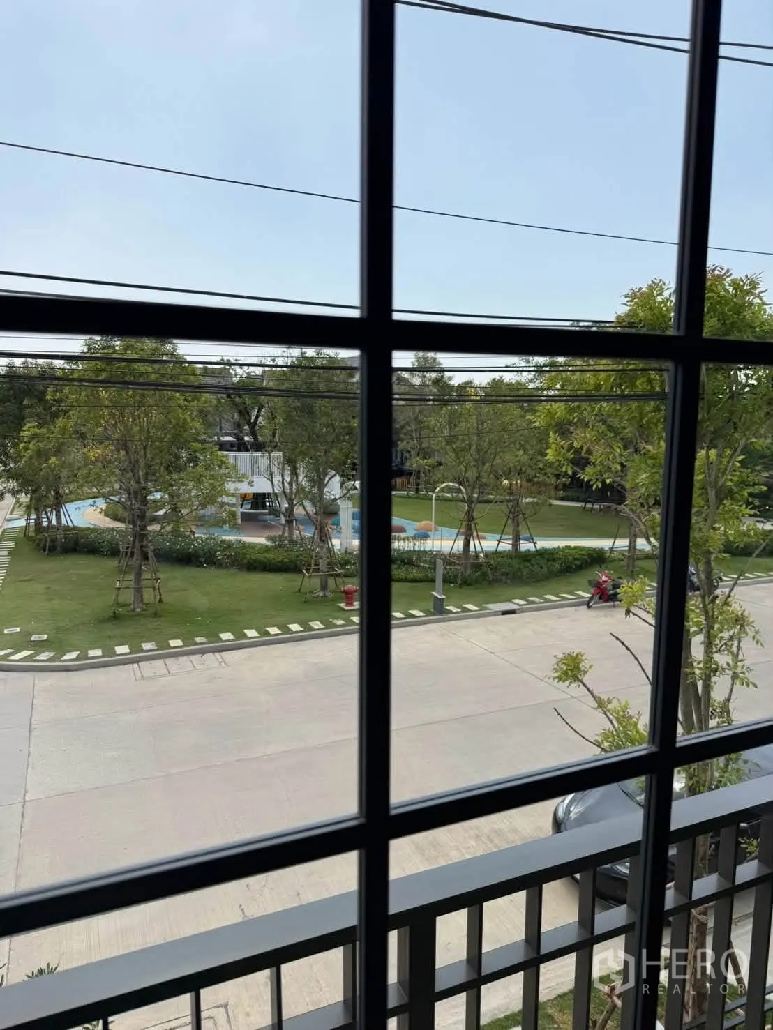 独栋房屋 for rent in Bang Phli, Samut Prakan - 透过窗户可见景观社区公园与游泳池。