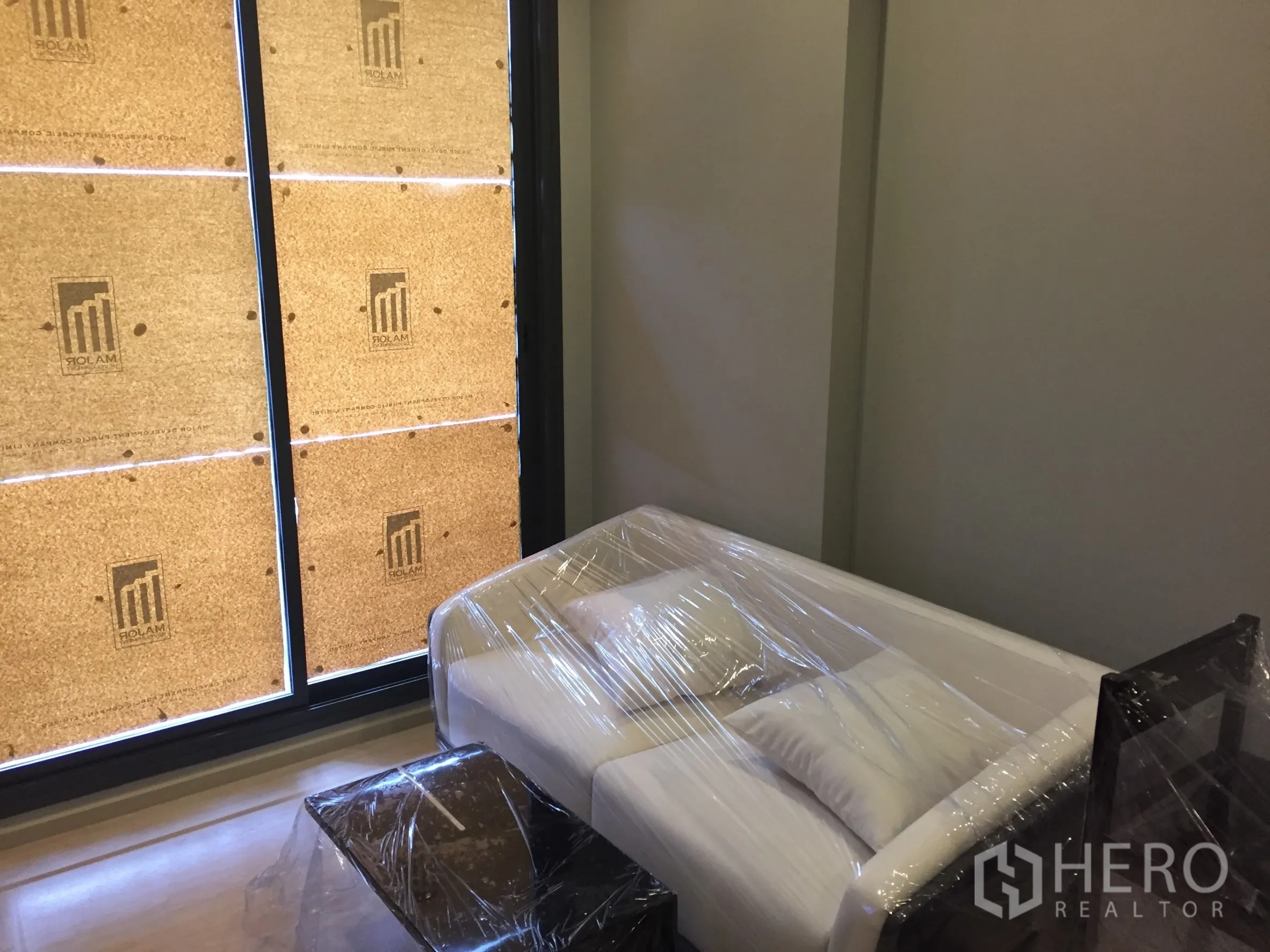 公寓 出租在Watthana, Bangkok - 客厅一角，白色沙发靠近落地窗。