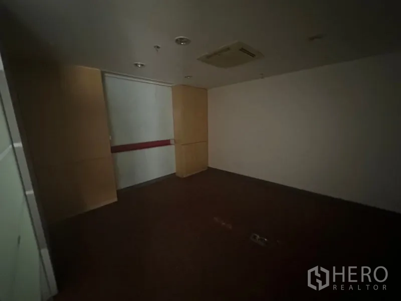 Office Space for rent in Khlong Toei, Bangkok - Windowless meeting room with wood panels and ceiling AC, suitable for presentations.