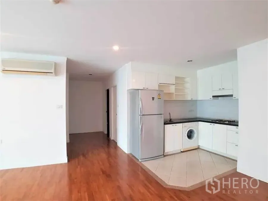 คอนโด ให้เช่าในSathon, Bangkok - โซนห้องนั่งเล่นเชื่อมครัว พื้นไม้ ตู้ครัวสีขาว และเครื่องปรับอากาศ