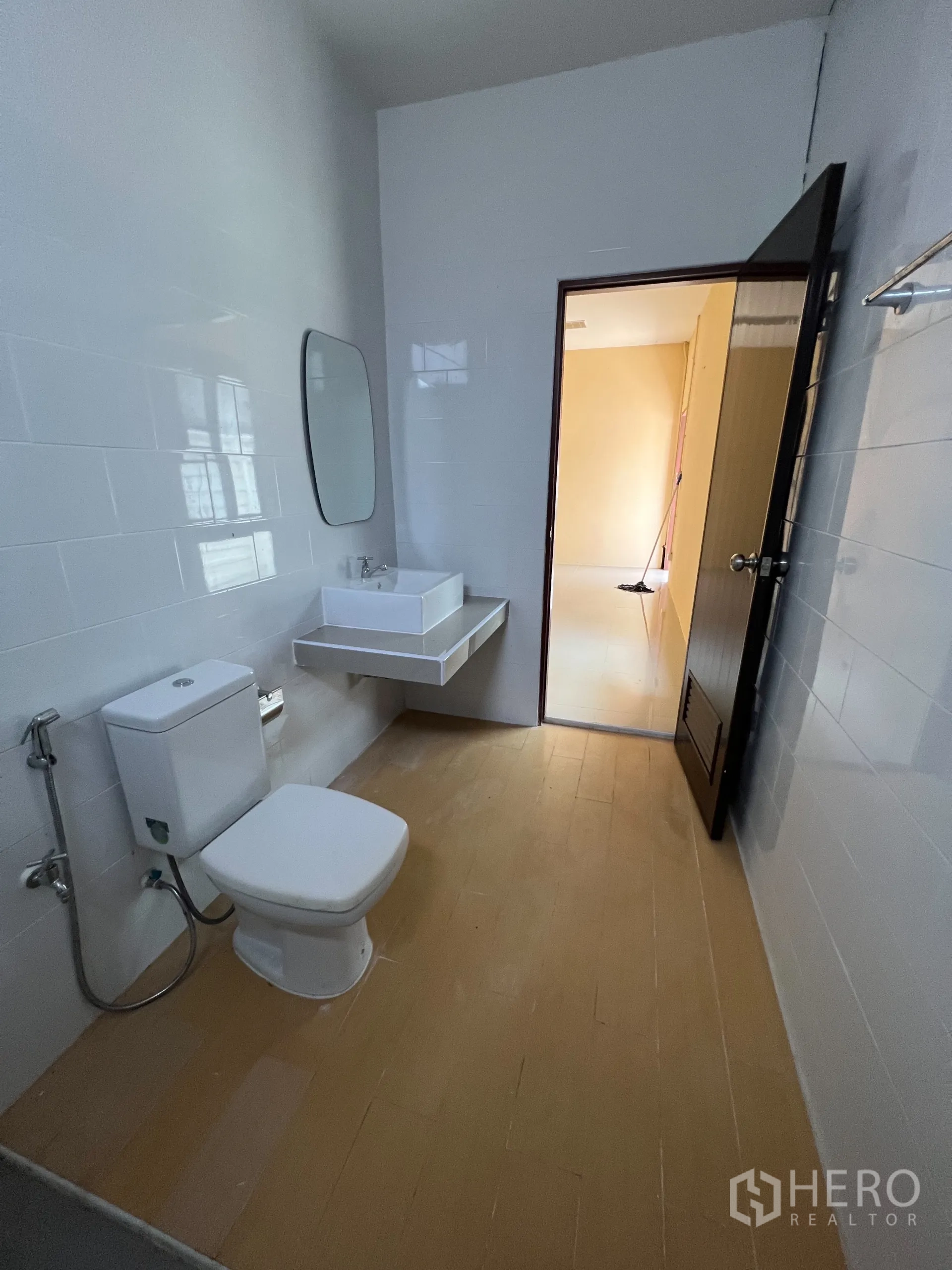 Warehouse for sale in Bang Len, Nakhon Pathom - Clean bathroom with toilet, wall-mounted sink and mirror.