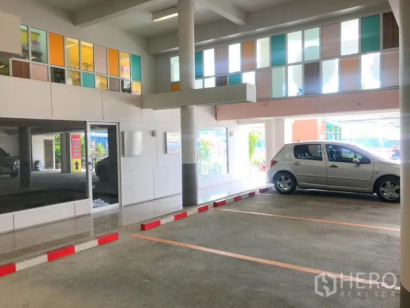 办公空间 出租在Suan Luang, Bangkok - 室内停车区，划线车位及彩色玻璃窗格。