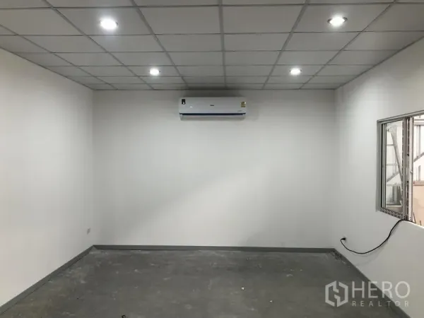Warehouse for rent in Nonthaburi - Air-conditioned office room with drop ceiling, recessed lighting and internal window overlooking the warehouse floor.