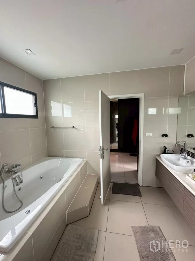 Detached House for sale in Bang Lamung, Chon Buri - Master bathroom with large soaking bathtub and double vanity.