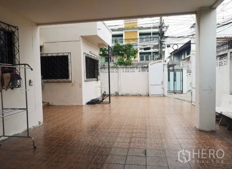 Detached House for sale in Khlong San, Bangkok - Spacious tiled courtyard and covered parking area behind a secure gate.