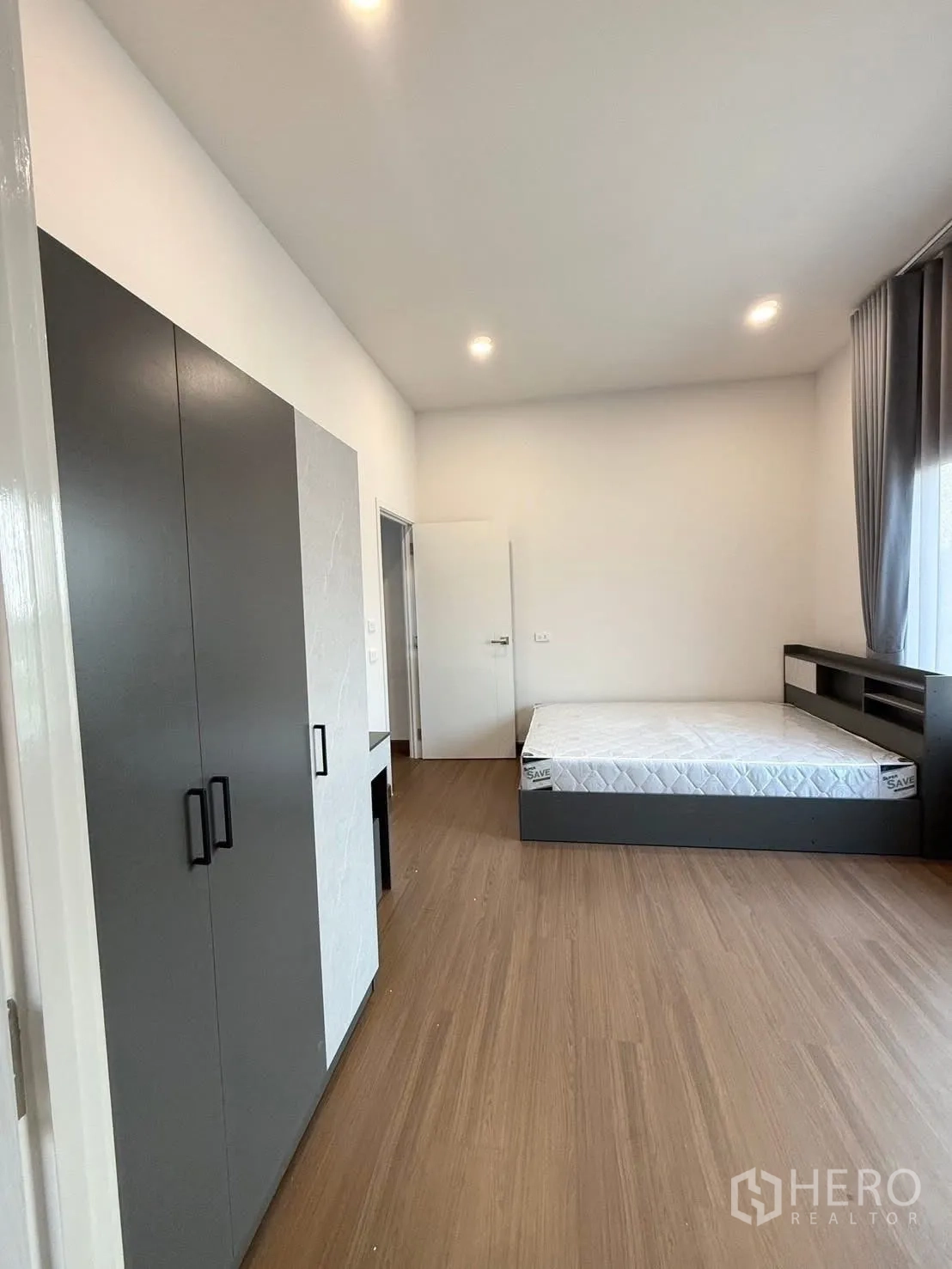 Detached House for rent in Bang Phli, Samut Prakan - Bright bedroom with wood flooring, bed frame and built-in wardrobe.