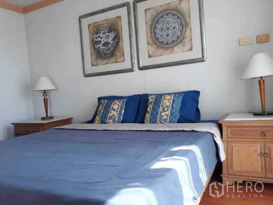 公寓 出租或出售在Khlong Toei, Bangkok - 主卧配大床与蓝色床品，双床头柜及墙面装饰画。