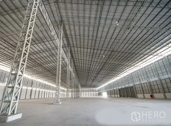 货栈 出租在Phra Nakhon Si Ayutthaya - 仓库内部通跨空间，高挑钢桁架屋顶与混凝土地面，位于旺诺县