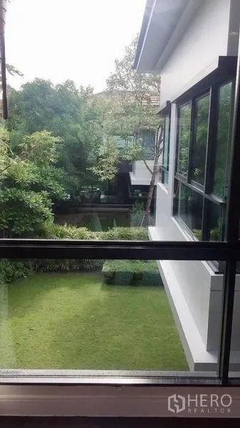 Detached House for rent in Bang Kapi, Bangkok - Upstairs window view over a private lawn, hedges and neighboring modern homes.