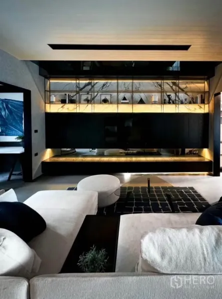 Townhouse for rent or sale in Bang Phli, Samut Prakan - Stylish living room featuring illuminated marble shelving, dark cabinetry and a low sectional sofa.