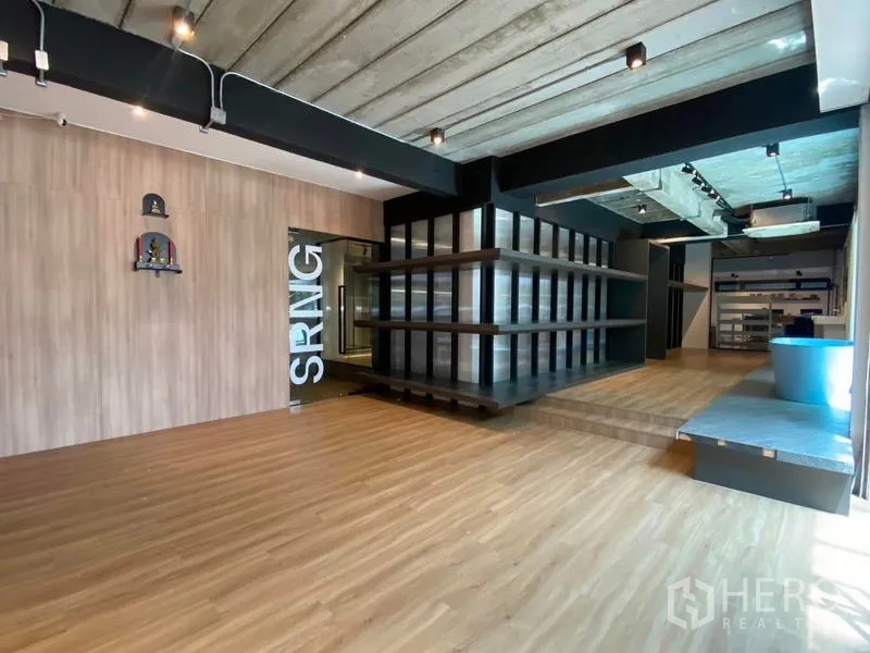 带办公室的家 出租在Wang Thonglang, Bangkok - 一层展示厅，木地板、裸露混凝土顶与轨道灯及陈列架