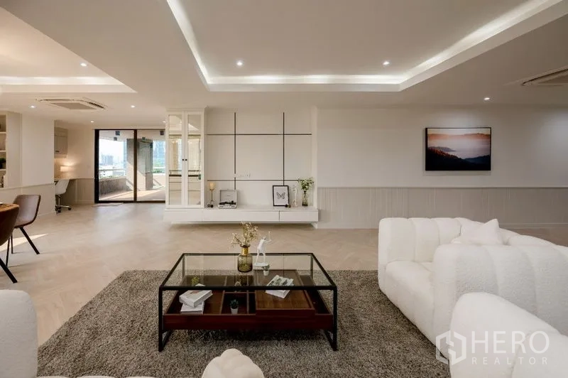 Condominium for sale - Living area with feature wall cabinetry and a glass coffee table.