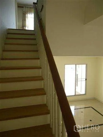 带办公室的家 出租或出售在Suan Luang, Bangkok - 室内木楼梯与扶手通向楼上，可见挑空区域。