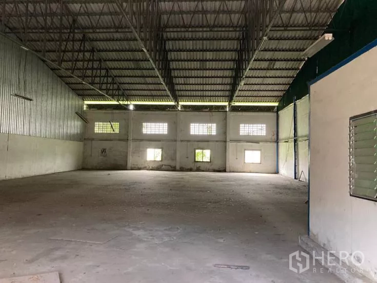 Factory for rent in Bang Phli, Samut Prakan - Spacious column-free factory interior with high steel truss roof, windows and concrete floor.
