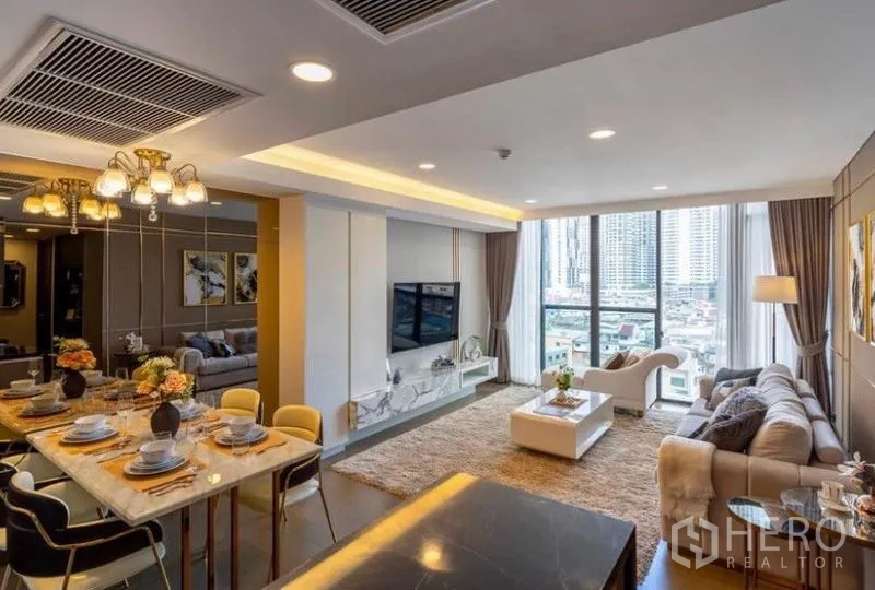 คอนโด ให้เช่าในKhlong Toei, Bangkok - โต๊ะทานอาหารหินอ่อนใต้โคมไฟ มองไปยังห้องนั่งเล่นกว้างและวิวเมือง