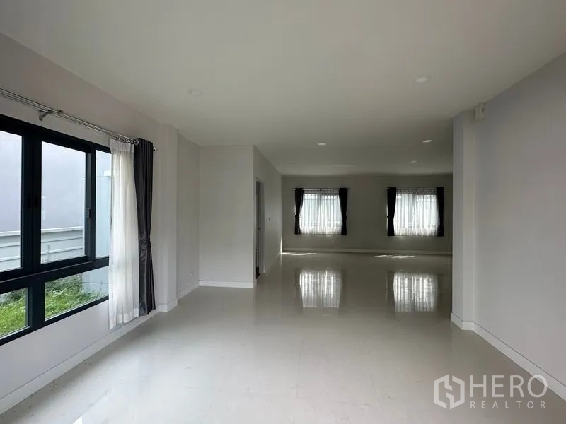 Detached House for sale in Nonthaburi - Spacious living and dining area with glossy tile flooring and large windows for natural light.