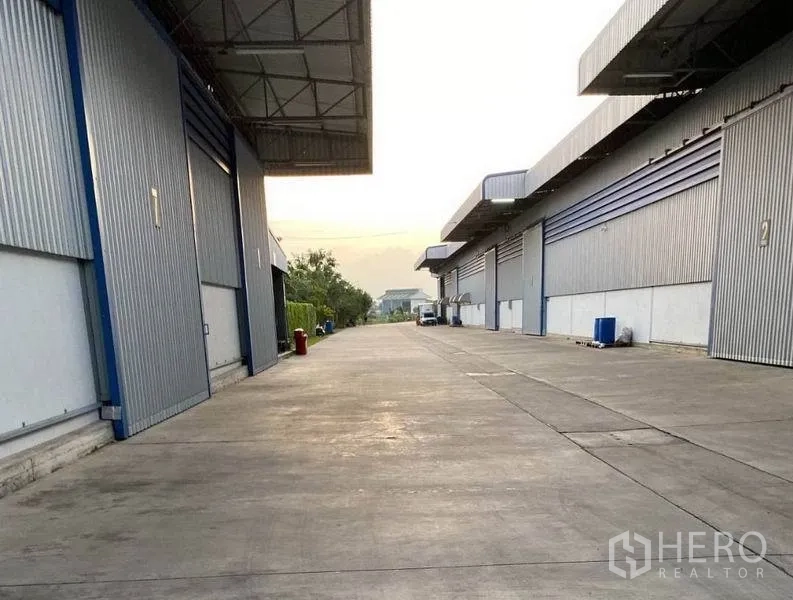 Warehouse for rent in Lat Krabang, Bangkok - Service lane between warehouses with deep canopies and sliding loading doors for trucks.