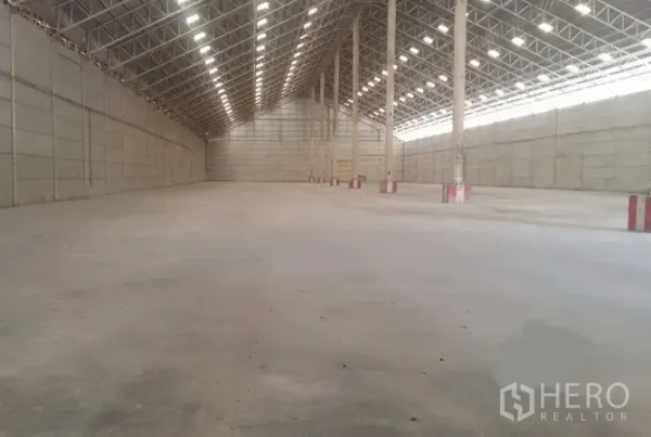 货栈 出租在Phra Nakhon Si Ayutthaya - 大跨度仓储大厅，整齐立柱与照明，平整混凝土地坪。