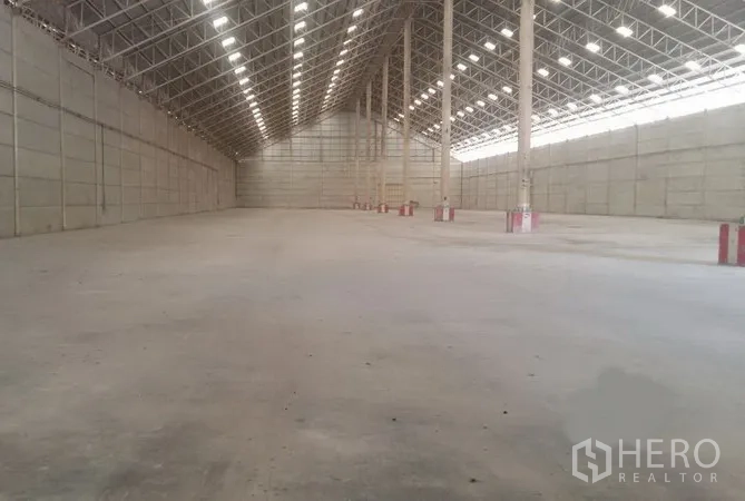 货栈 出租在Phra Nakhon Si Ayutthaya - 大跨度仓储大厅，整齐立柱与照明，平整混凝土地坪。