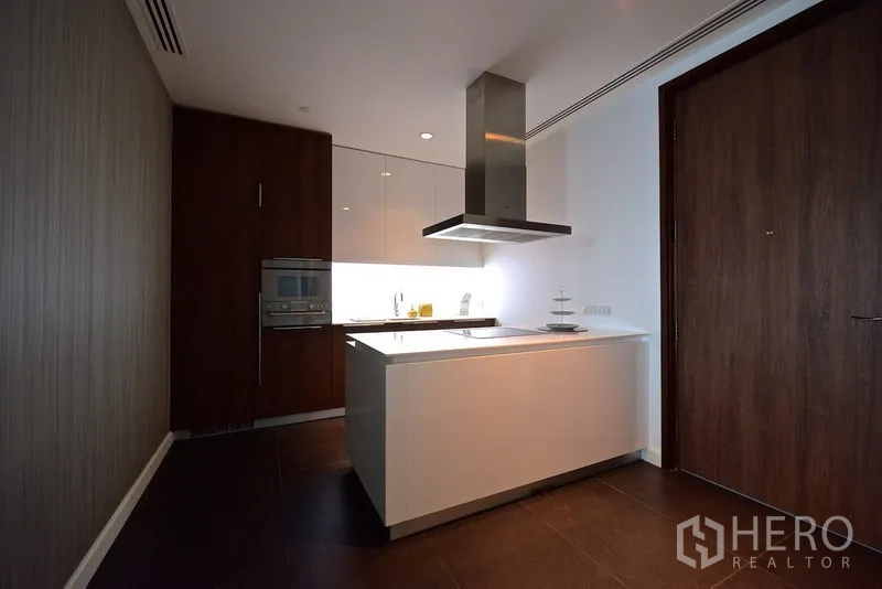 Condominium for rent in Pathum Wan, Bangkok - Sleek kitchen with central island, built-in oven and stainless-steel hood in a contemporary condominium.