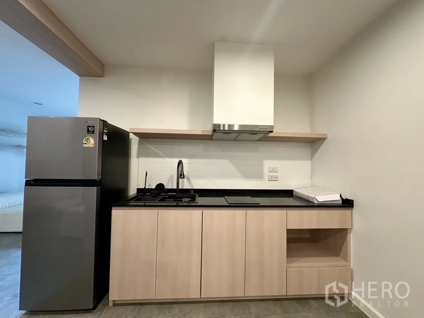 带办公室的家 出租在Phra Khanong, Bangkok - 紧凑现代厨房，配冰箱、炉灶、抽油烟机与黑色台面。