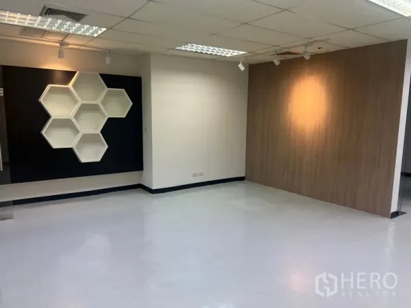办公空间 出租在Watthana, Bangkok - 开放式办公区，蜂巢造型展示架与聚光灯点缀。