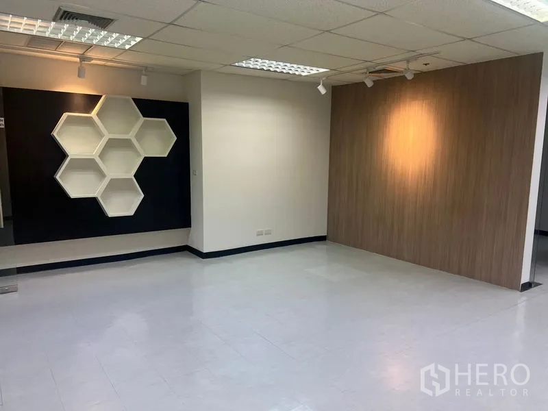 办公空间 出租在Watthana, Bangkok - 开放式办公区，蜂巢造型展示架与聚光灯点缀。
