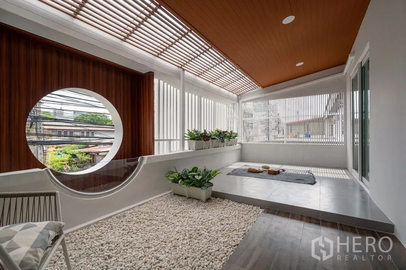Townhouse for sale in Din Daeng, Bangkok - Zen-style terrace corner with pebble garden, circular viewing window and seating area.