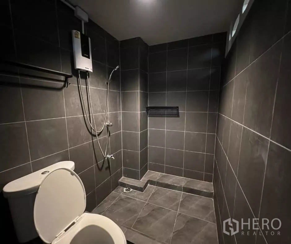 ทาวน์เฮาส์ ให้เช่า - ห้องน้ำรีโนเวท กระเบื้องสีเข้ม ฝักบัวแบบวอล์กอิน และเครื่องทำน้ำอุ่น